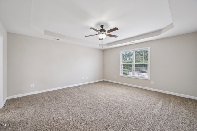 265 Wind Swept St, Raeford, NC 28376 - spare room featuring a tray ceiling, a ceiling fan, carpet floors, and baseboards
