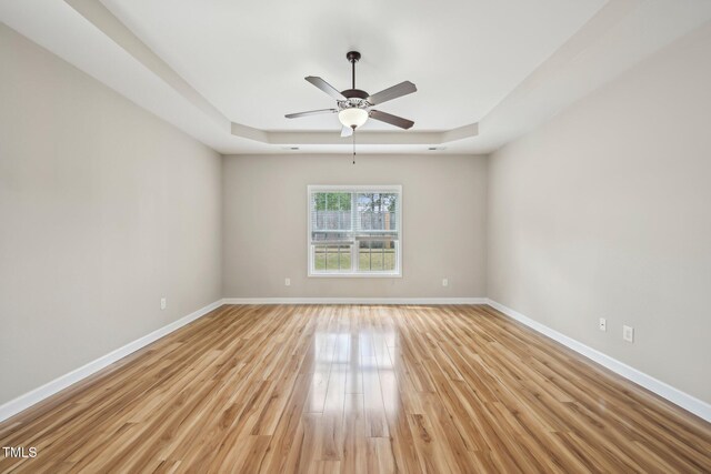 265 Wind Swept St, Raeford, NC 28376 - unfurnished room with a tray ceiling, light wood-style floors, baseboards, and ceiling fan