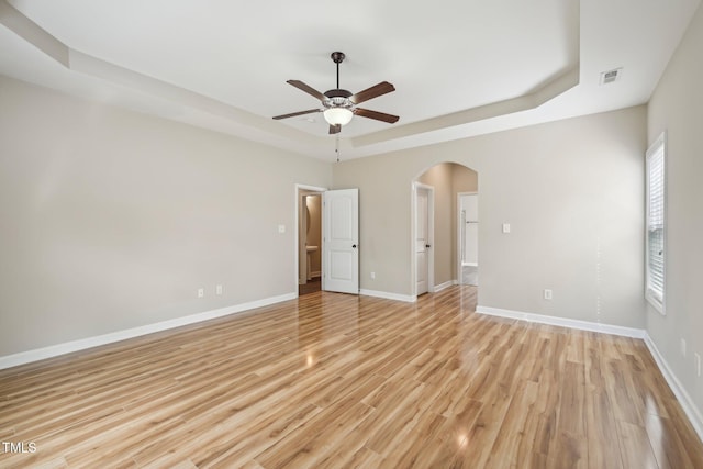 265 Wind Swept St, Raeford, NC 28376 - empty room with a tray ceiling, arched walkways, ceiling fan, light wood finished floors, and baseboards