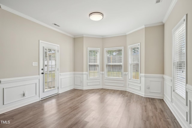 265 Wind Swept St, Raeford, NC 28376 - empty room with healthy amount of natural light, wood finished floors, a wainscoted wall, and crown molding