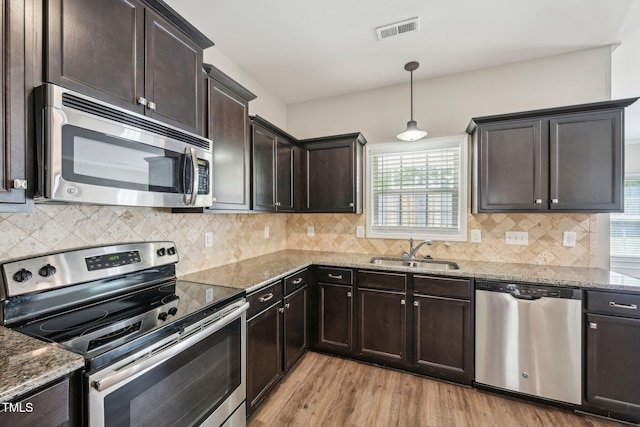 265 Wind Swept St, Raeford, NC 28376 - kitchen with stainless steel appliances, a sink, light wood-type flooring, and stone counters