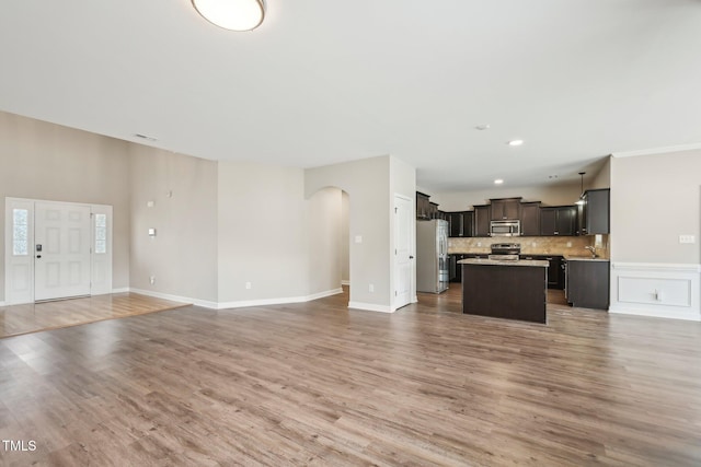 265 Wind Swept St, Raeford, NC 28376 - kitchen with stainless steel appliances, open floor plan, a kitchen island, arched walkways, and light countertops