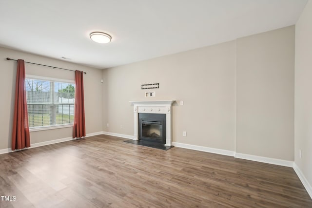 265 Wind Swept St, Raeford, NC 28376 - unfurnished living room with wood finished floors, a glass covered fireplace, and baseboards
