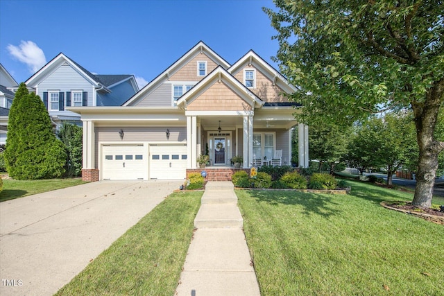 view of front facade with an attached garage, a front yard, concrete driveway, and covered porch