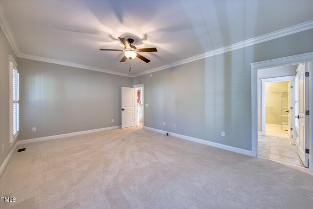 unfurnished room featuring ceiling fan, crown molding, light carpet, and baseboards
