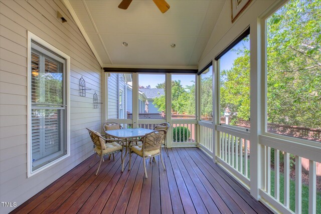 sunroom featuring ceiling fan, outdoor dining area, and lofted ceiling