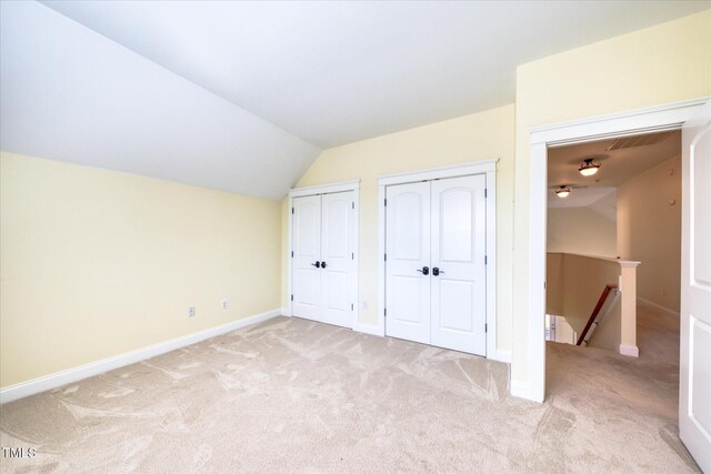 bonus room featuring light carpet, lofted ceiling, and baseboards