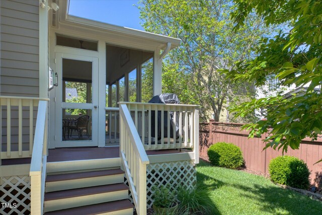 wooden terrace featuring fence and a sunroom
