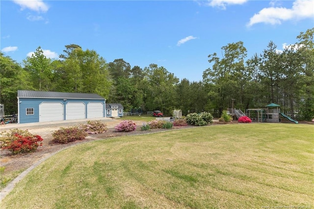 view of yard featuring a playground, an outdoor structure, and a garage