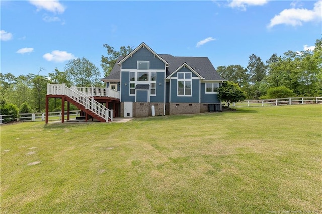 back of property with a yard, fence, stairway, and a deck