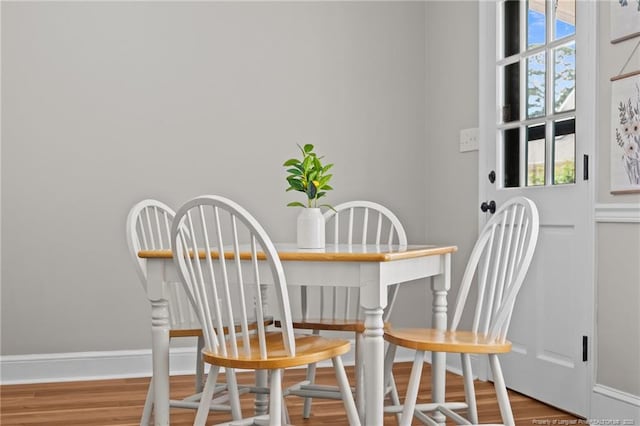 dining room featuring baseboards, plenty of natural light, and wood finished floors