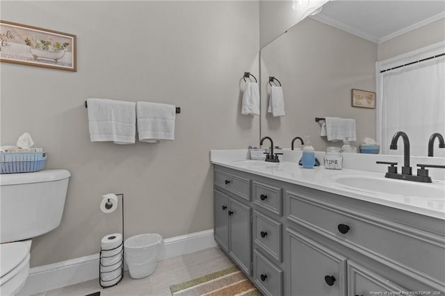 bathroom with crown molding, toilet, baseboards, and a sink