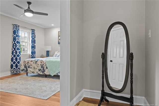 entrance foyer featuring wood finished floors, crown molding, baseboards, and ceiling fan