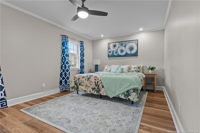 bedroom with wood finished floors, baseboards, and ornamental molding