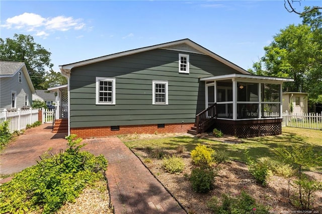 rear view of house featuring a sunroom and crawl space