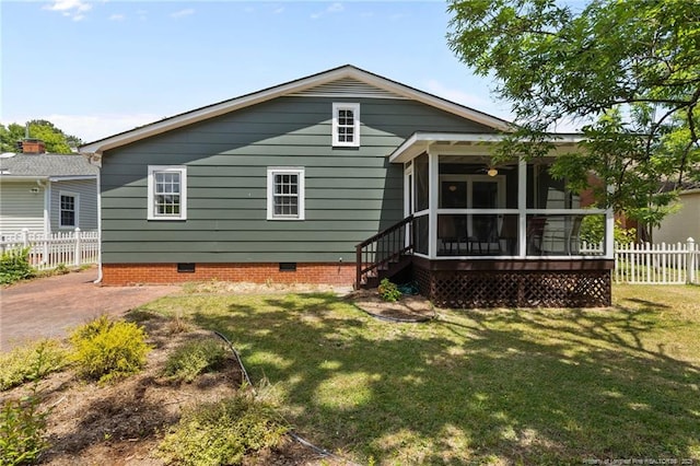 rear view of house with a lawn, a sunroom, fence, and crawl space