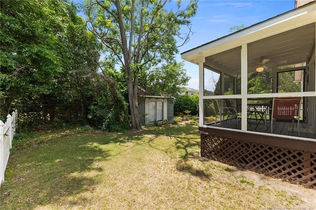 view of yard with a wooden deck, a storage shed, an outbuilding, and a sunroom