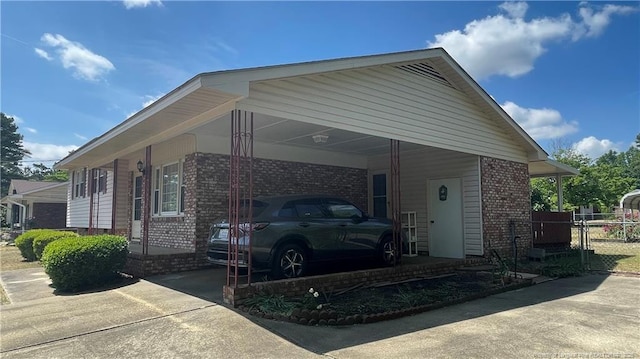 3412 Seven Mountain Dr, Fayetteville, NC 28306 - view of side of home with brick siding, concrete driveway, an attached carport, and a gate