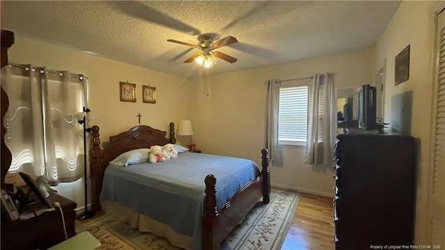 3412 Seven Mountain Dr, Fayetteville, NC 28306 - bedroom with light wood finished floors, a textured ceiling, and a ceiling fan