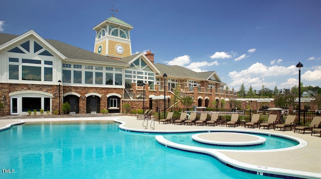 community pool with a patio and fence