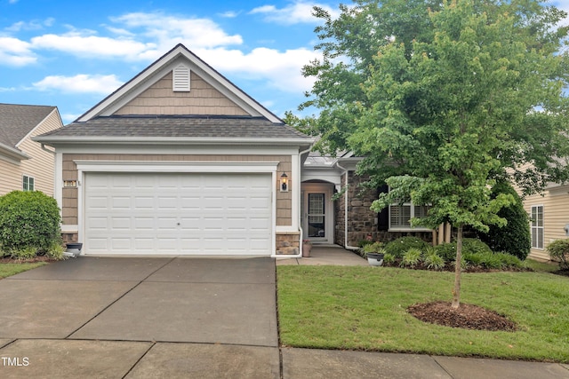 view of front facade with concrete driveway, a front lawn, stone siding, and a shingled roof