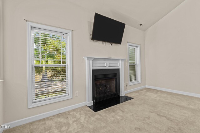 309 Coachmans Trl, Stem, NC 27581 - unfurnished living room featuring carpet flooring, vaulted ceiling, baseboards, and a fireplace with flush hearth