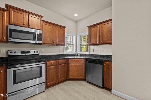 309 Coachmans Trl, Stem, NC 27581 - kitchen featuring stainless steel appliances, a sink, light wood-type flooring, dark stone counters, and recessed lighting