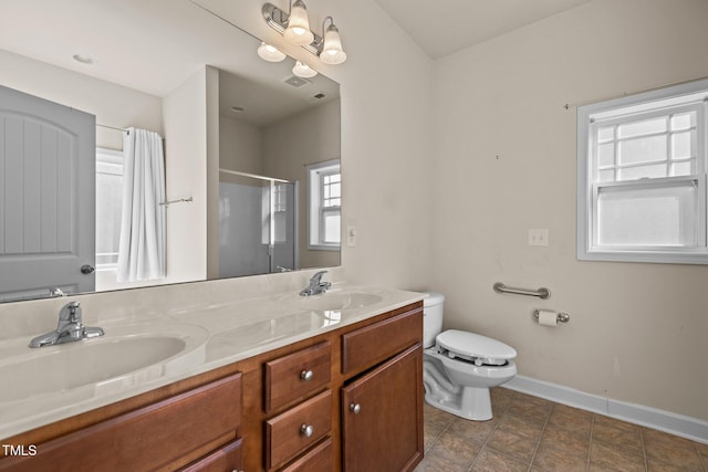 309 Coachmans Trl, Stem, NC 27581 - full bathroom with a stall shower, toilet, double vanity, and baseboards