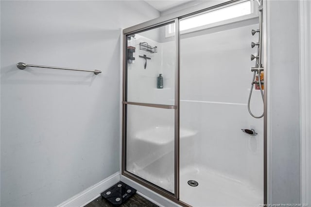 full bathroom featuring a stall shower and baseboards