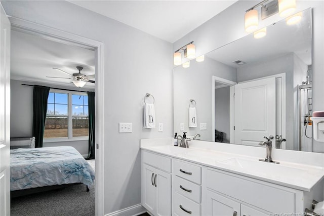 bathroom featuring ensuite bathroom, double vanity, baseboards, and ceiling fan