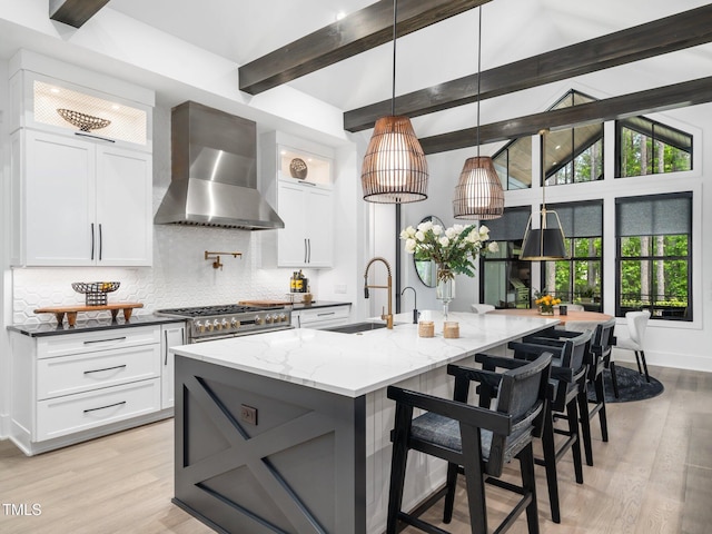 604 Dappled Pine Ave, Durham, NC 27713 - kitchen featuring wall chimney exhaust hood, a sink, decorative backsplash, white cabinetry, and light stone countertops