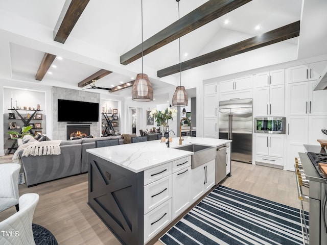 604 Dappled Pine Ave, Durham, NC 27713 - kitchen featuring built in appliances, a sink, beam ceiling, white cabinets, and light wood-style floors