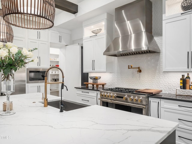 604 Dappled Pine Ave, Durham, NC 27713 - kitchen with wall chimney exhaust hood, appliances with stainless steel finishes, a sink, decorative backsplash, and white cabinets