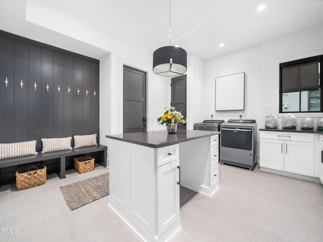 604 Dappled Pine Ave, Durham, NC 27713 - kitchen with washing machine and dryer, white cabinetry, dark countertops, recessed lighting, and range