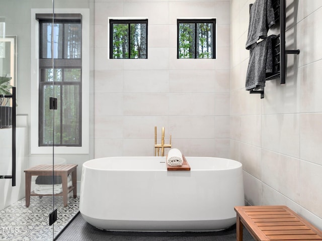 604 Dappled Pine Ave, Durham, NC 27713 - bathroom featuring tile walls and a freestanding bath