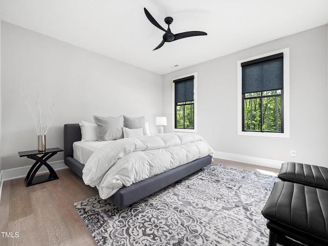 604 Dappled Pine Ave, Durham, NC 27713 - bedroom featuring multiple windows, wood finished floors, baseboards, and a ceiling fan