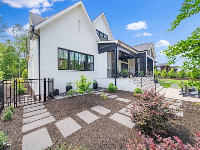 604 Dappled Pine Ave, Durham, NC 27713 - back of house featuring a sunroom, a patio area, and brick siding