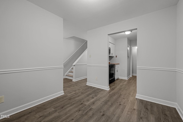 1131 Schaub Dr, Raleigh, NC 27606 - empty room featuring dark wood-style floors, baseboards, and stairs