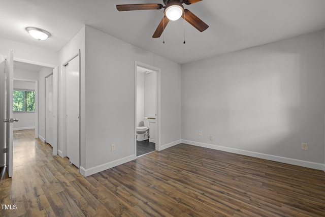 1131 Schaub Dr, Raleigh, NC 27606 - unfurnished bedroom with dark wood finished floors, baseboards, and connected bathroom