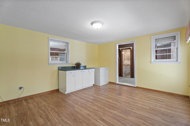 5517 Spring Rd, Raleigh, NC 27603 - empty room featuring light wood finished floors, baseboards, and a textured ceiling