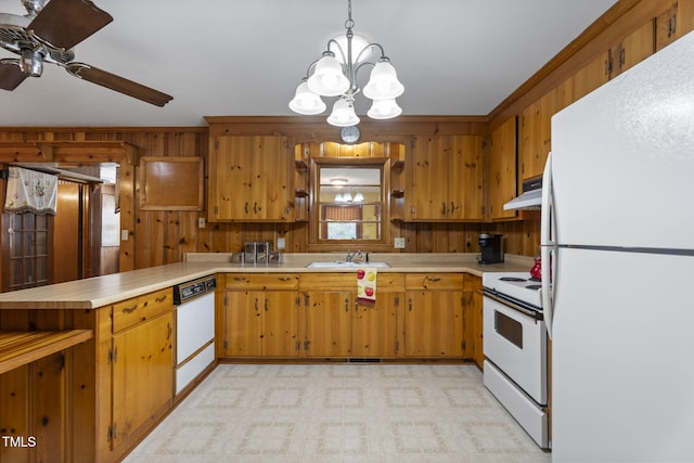 5517 Spring Rd, Raleigh, NC 27603 - kitchen featuring white appliances, under cabinet range hood, light countertops, a peninsula, and a chandelier
