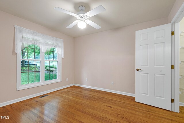 spare room with light wood-style flooring, baseboards, and ceiling fan