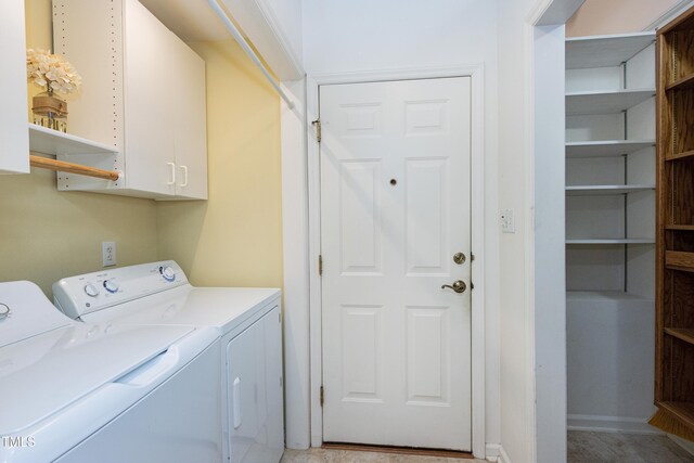 clothes washing area featuring cabinet space and separate washer and dryer