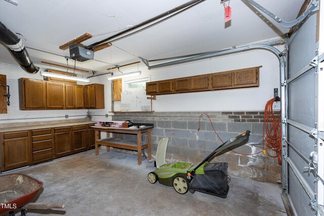 garage featuring a garage door opener and concrete block wall