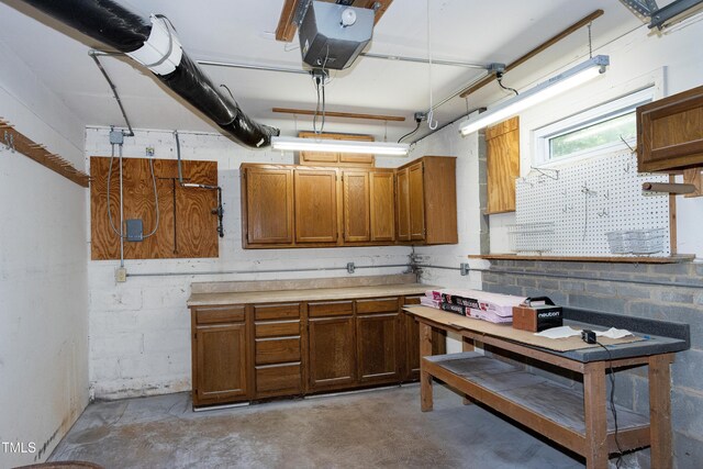 kitchen featuring concrete floors, brown cabinets, and light countertops