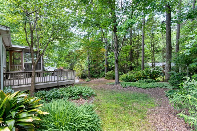 view of yard featuring a sunroom and a wooden deck