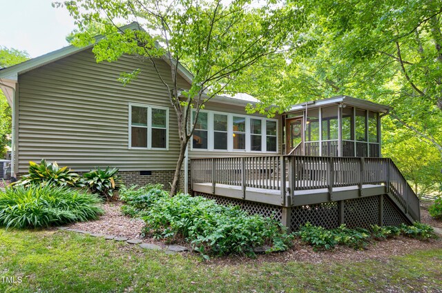 rear view of house featuring a sunroom, a deck, crawl space, and central AC unit