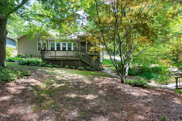 rear view of house with a deck, a sunroom, and stairs
