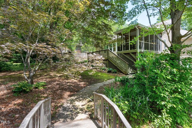 view of yard featuring a sunroom and stairs