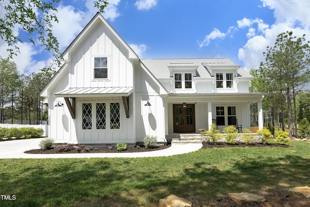 modern farmhouse with a standing seam roof, board and batten siding, and a front yard